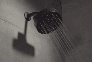 Power Shower smart shower in black finish with water coming out.