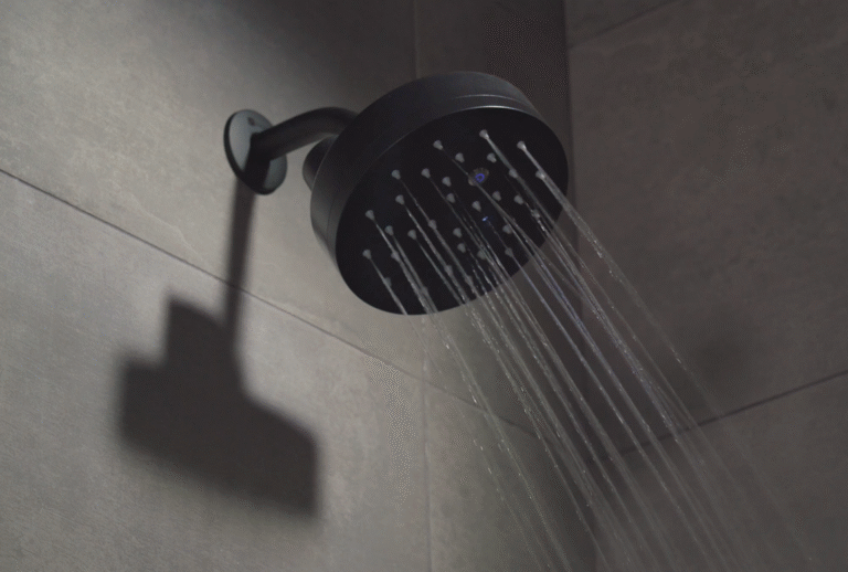 Power Shower smart shower in black finish with water coming out.