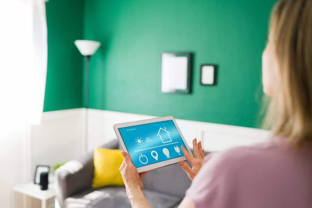 Woman using an app on the tablet to turn on her lights with a smart device