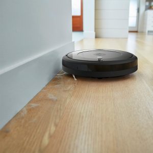 Roomba 694 cleaning up a dirty wood floor.