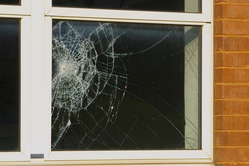 Broken window on brick house