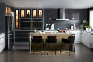 Modern kitchen in grey tones with lit cabinets.