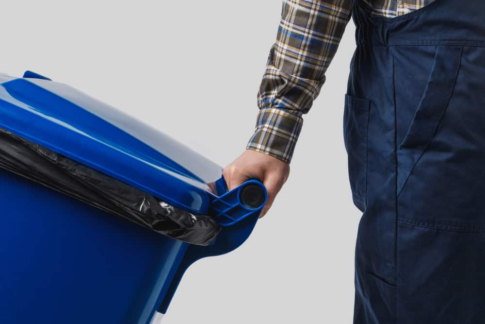 Person with blue trash bin.
