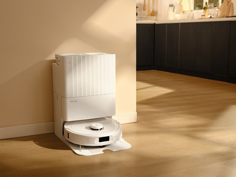 Roborock Q Revo cleaner with docking station against a beige wall.