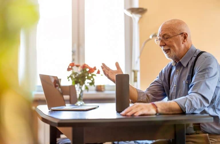 Senior man using voice assistant