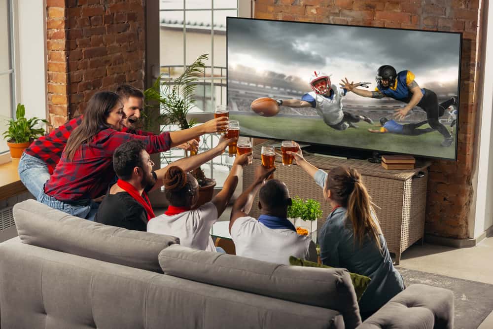 Friends watching football game on tv.
