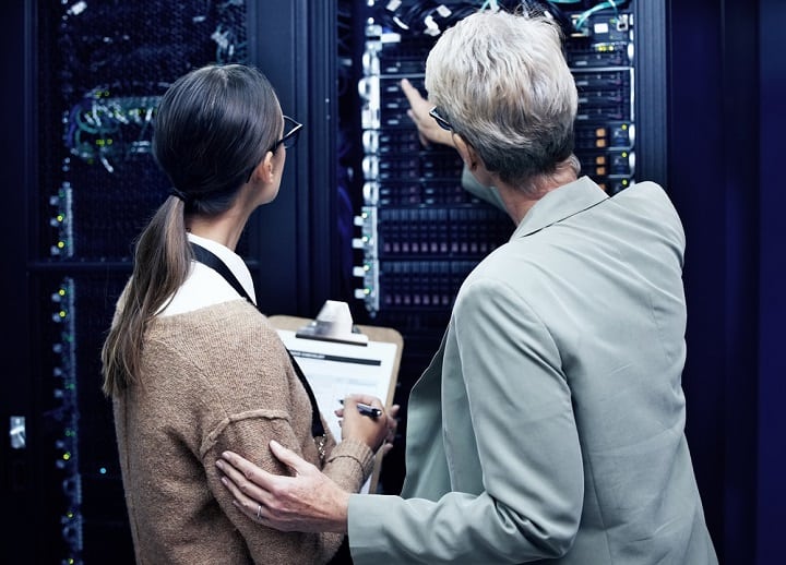 Two IT techs in front of a server rack.