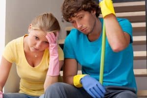 Man and woman on stairs sad about cleaning