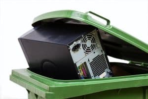 Computer tower in a recycling bin.