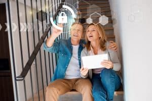 man and woman on stairs pointing at smart home lock