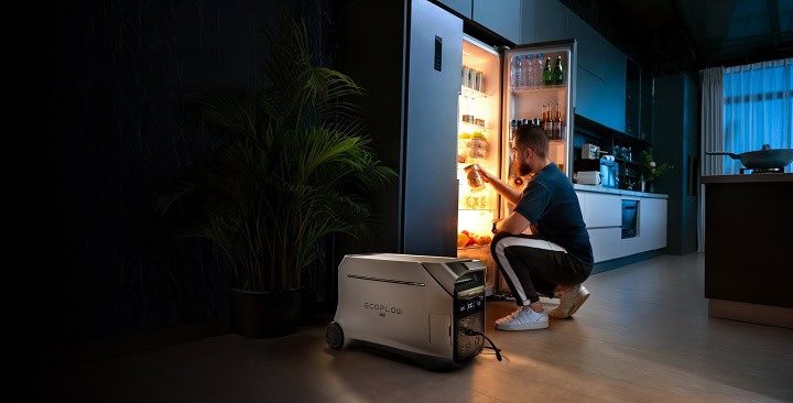 EcoFlow Delta Pro 3 and a man looking inside a powered refrigerator.