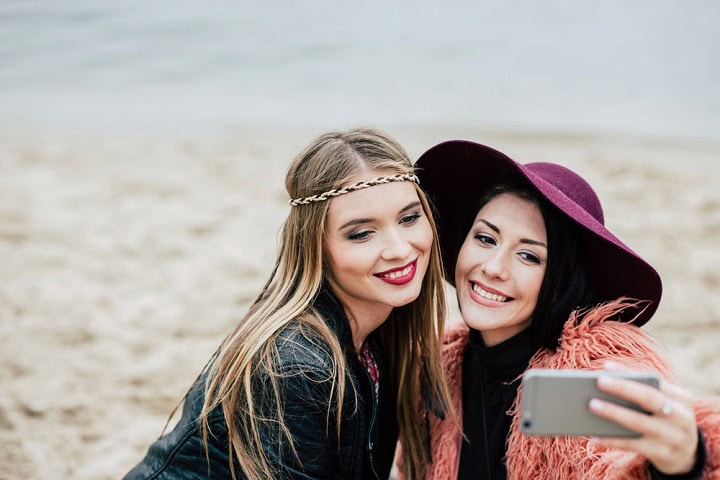 Two women taking a selfie on a beach.
