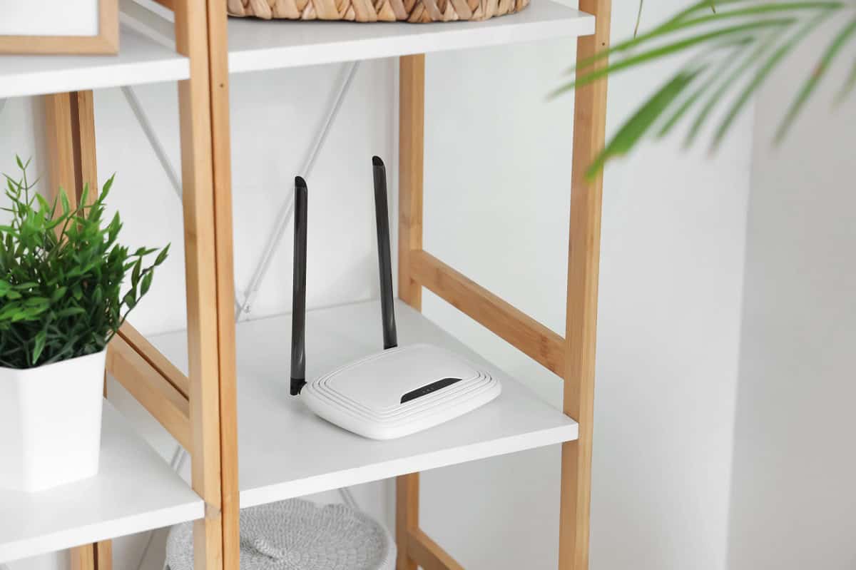 White router on a white and wooden shelf.
