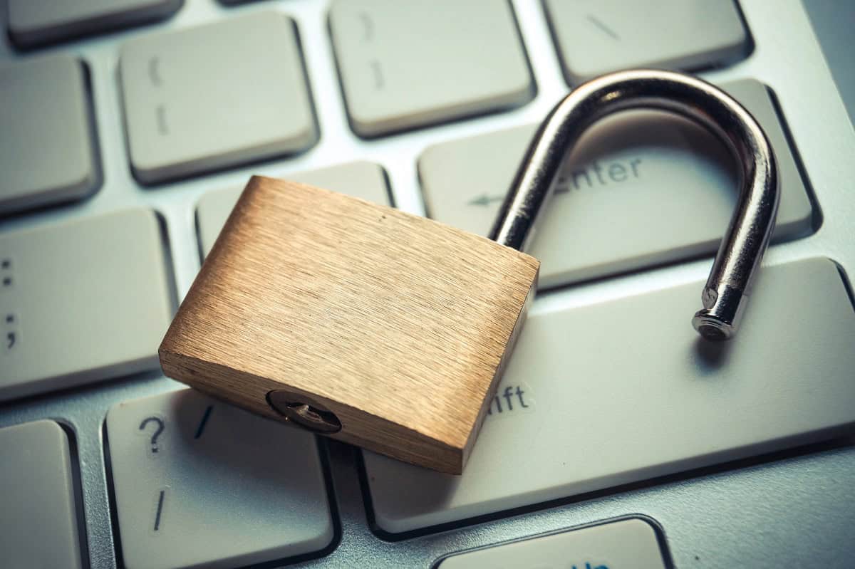 Open padlock sitting on a laptop keyboard.