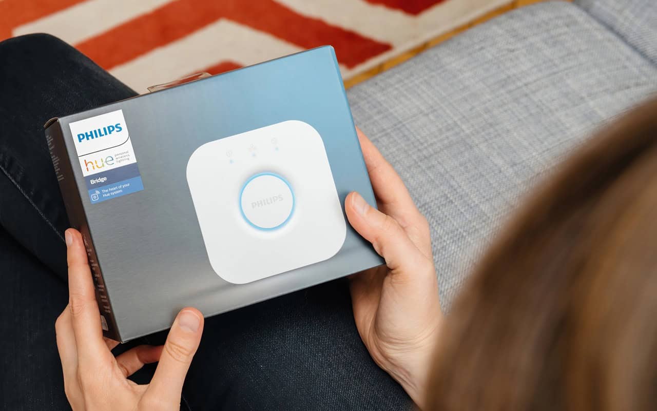 Woman holding a Philips Hue Smart Bridge.